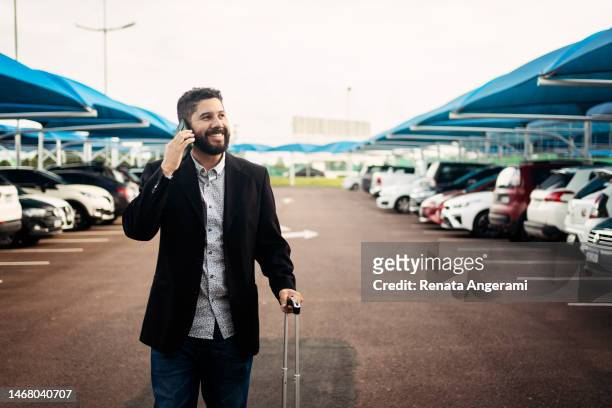 hombre caminando en el estacionamiento del aeropuerto - lot of people fotografías e imágenes de stock