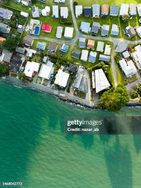 settlement next to beach. - new zealand beach house stock pictures, royalty-free photos & images