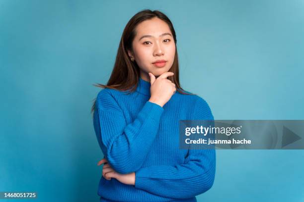 young woman touching chin and looking at camera. thinking gesture - female models photo gallery stock pictures, royalty-free photos & images