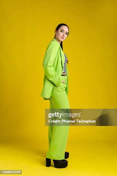 fashionable woman wearing green suit - hands in pockets fotografías e imágenes de stock