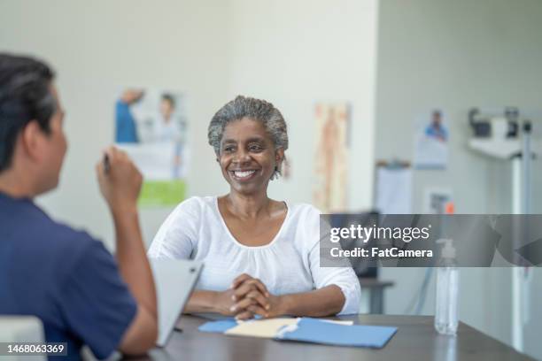 senior at a doctors appointment - medicaid stockfoto's en -beelden