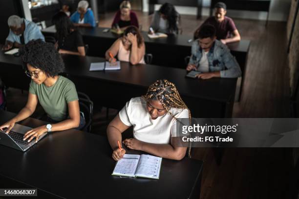 estudiante tomando notas durante la clase - college admissions fotografías e imágenes de stock