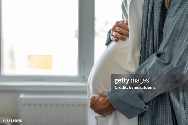 pregnant woman with big belly in hands - maternity leave stockfoto's en -beelden