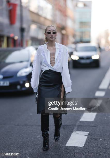 Betty Bach seen wearing a black skirt with lace, a white blouse and black boots before the Christopher Kane show during London Fashion Week on...