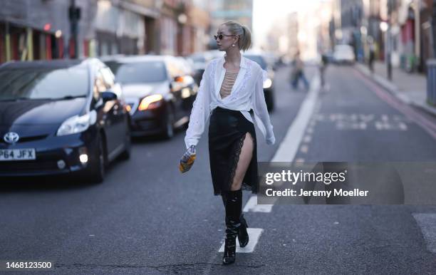 Betty Bach seen wearing a black skirt with lace, a white blouse and black boots before the Christopher Kane show during London Fashion Week on...