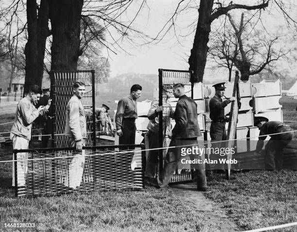 Military personnel from Aldershot, preparing portable beds at a military camp in Kensington Gardens, London, England, 19th April 1937. Kensington...