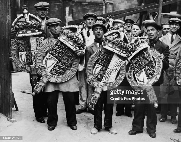 Labourers carrying coats of arms for hanging in Westminster Abbey in London, England, 13th April 1937. The abbey is prepared for the coronation of...