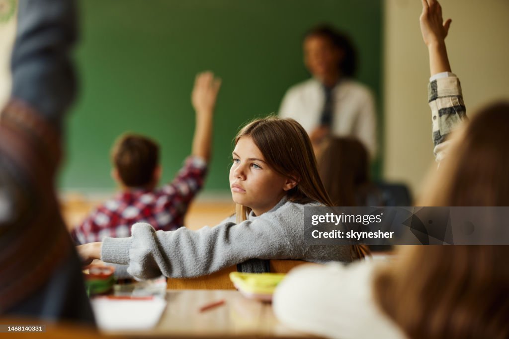 Thoughtful schoolgirl among her classmates at elementary school.