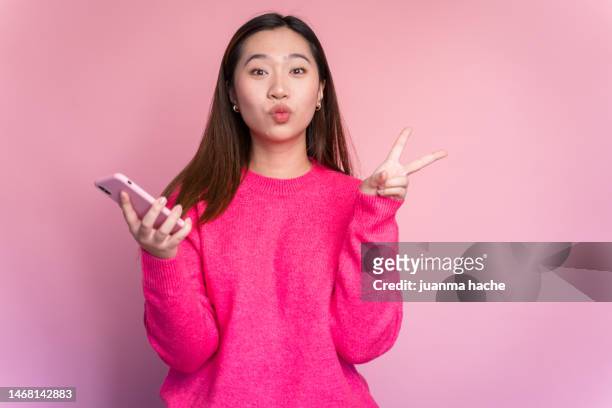 happy asian woman with smartphone - fashion awards inside stockfoto's en -beelden