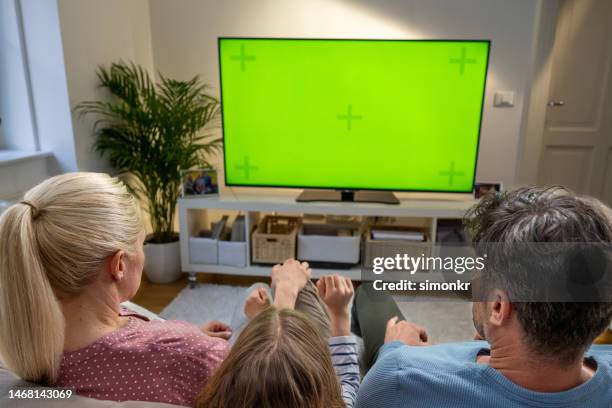 family watching tv - television show stock pictures, royalty-free photos & images