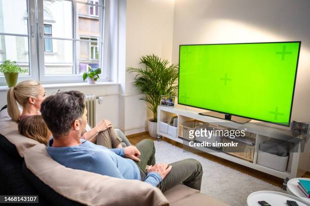 family watching tv - television show stock pictures, royalty-free photos & images