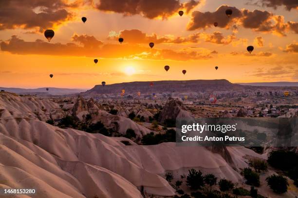 hot air balloons at sunrise over the beautiful landscape in cappadocia, turkey - capadócia imagens e fotografias de stock