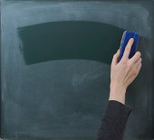 Hand cleaning blackboard with chalkboard rubber