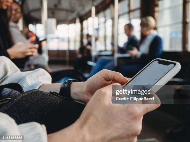 una mujer usa un smartphone en el tranvía de milán - grupo mediano de personas fotografías e imágenes de stock