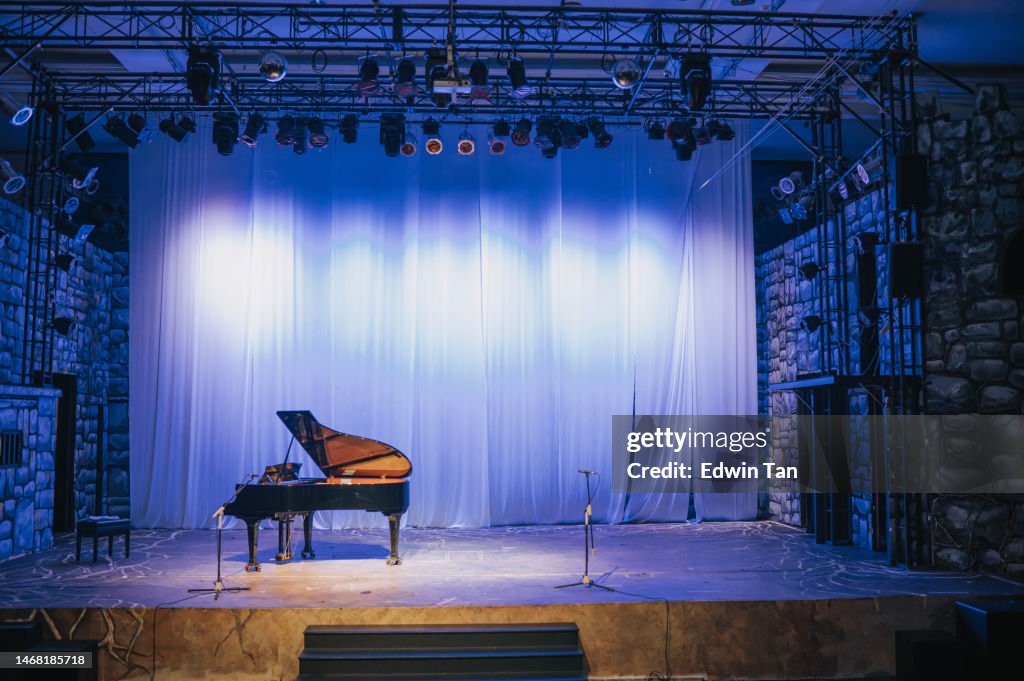 Teatro de escenario musical con piano de cola y fondo blanco iluminado con luz escénica