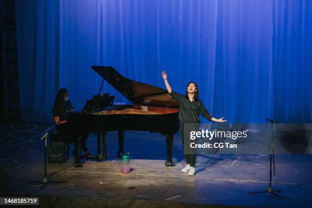 giovane cantante d'opera cinese asiatica che si esercita da sola sul palco con il pianista - cantante dopera foto e immagini stock