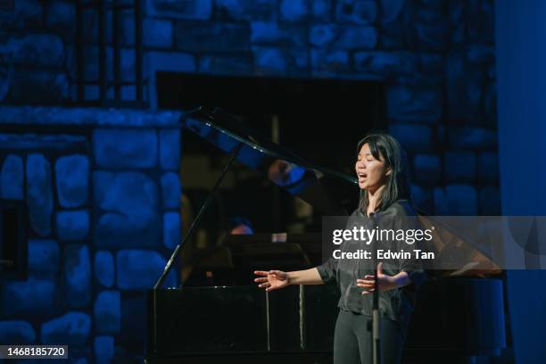asiatisch-chinesische junge opernsängerin beim solo-bühnenauftritt - opera stage stock-fotos und bilder
