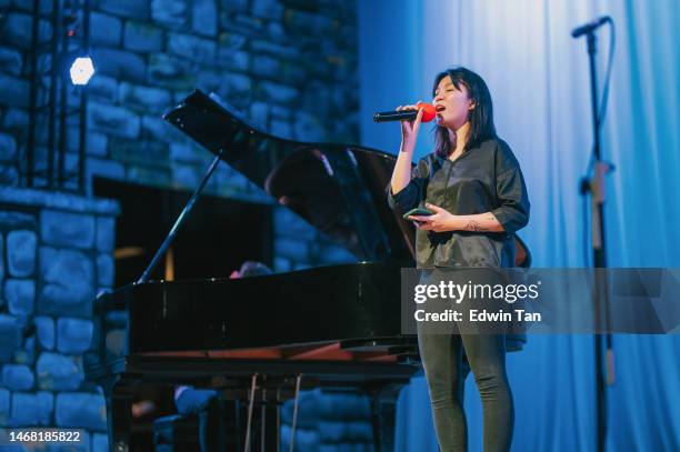 asian chinese young female opera singer enjoy practising solo on stage with pianist - sopranos stock pictures, royalty-free photos & images