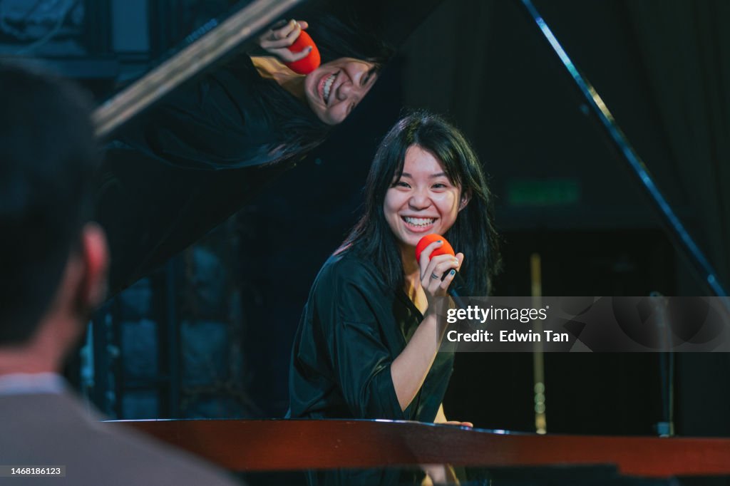 Joven cantante de ópera asiática china disfruta practicando solo en el escenario con pianista