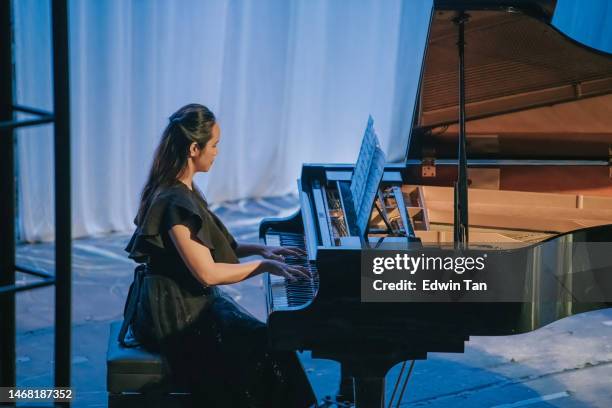 asian chinese female pianist performing solo on stage - muzieksymbool stockfoto's en -beelden