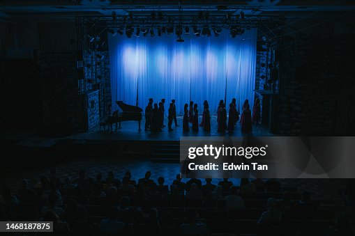 in silhouette choir getting ready on stage theatre