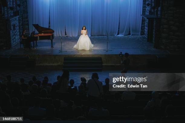 giovane cantante lirica femminile cinese che si esibisce da sola sul palco con il pianista - spettatore opera foto e immagini stock