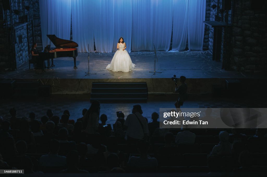 Young Chinese Female opera singer performing solo on stage with Pianist