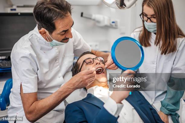 dental check-up for a young man at the dentist - implante dentário imagens e fotografias de stock