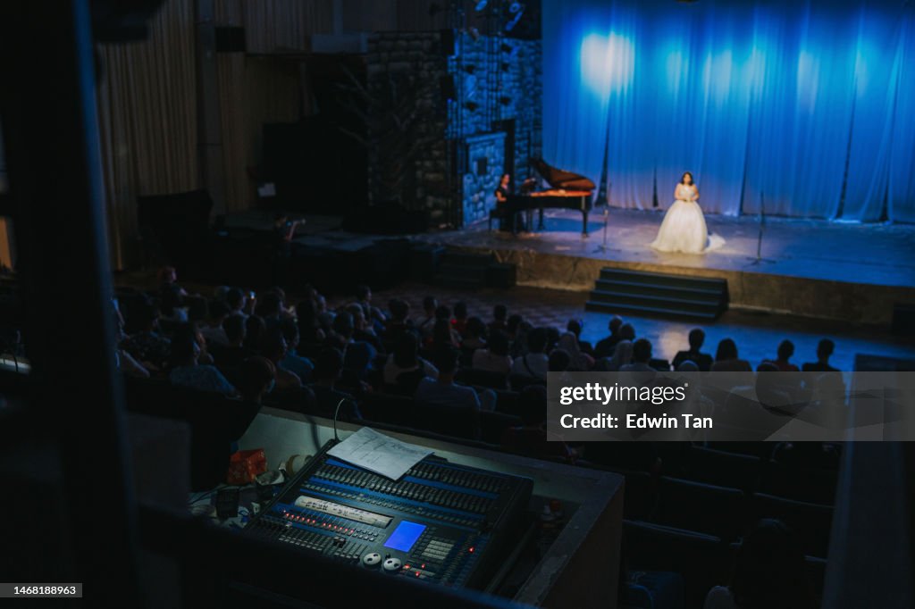 Junge chinesische Opernsängerin solo auf der Bühne mit Pianist vor Publikum