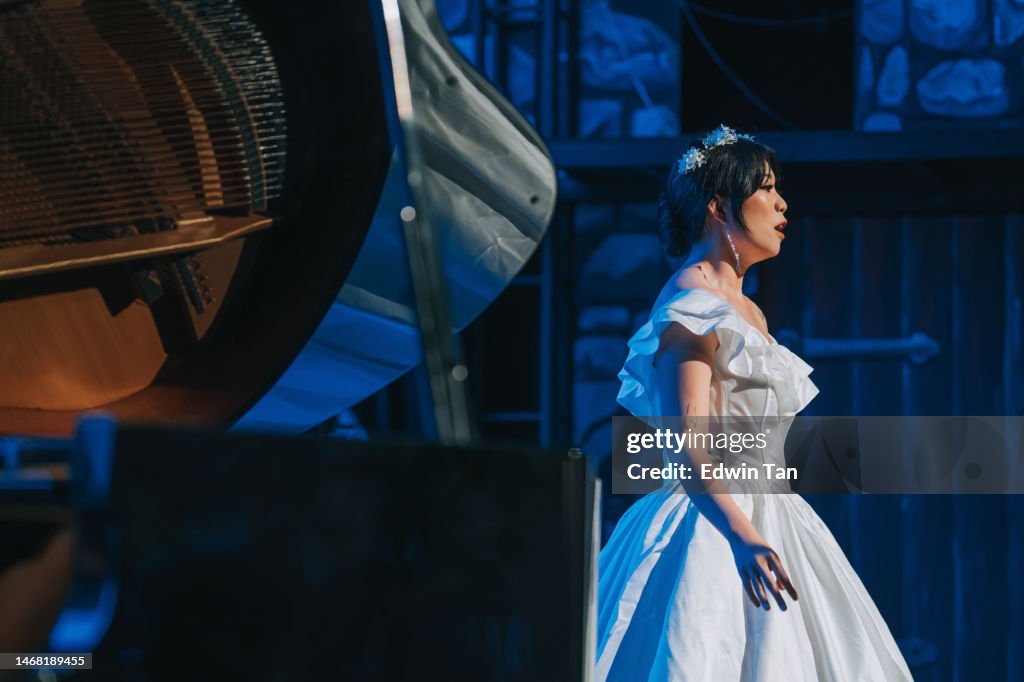 Young Chinese Female opera singer performing solo on stage with Pianist