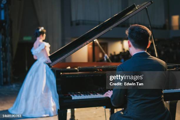 asian chinese pianist playing grand piano with female opera singer performing solo on stage - sopranos stock pictures, royalty-free photos & images