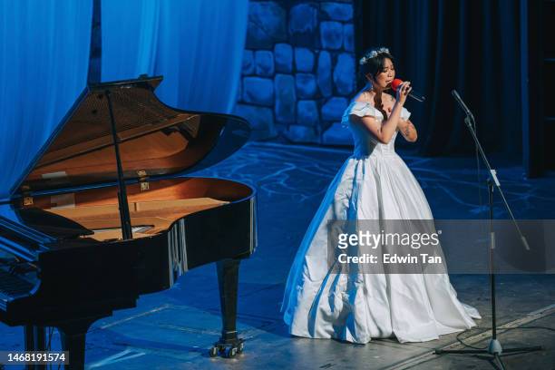 young chinese female opera singer performing solo on stage with pianist - soprano singer stock pictures, royalty-free photos & images