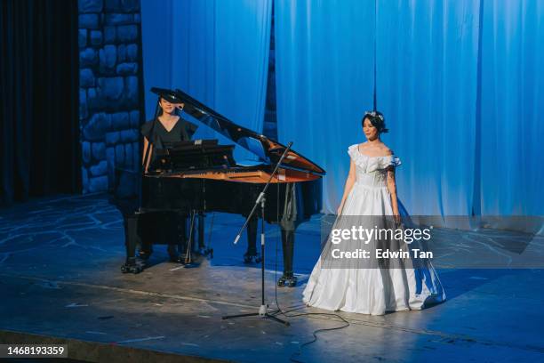 young chinese female opera singer performing solo on stage with pianist in front of audience - soprano singer stock pictures, royalty-free photos & images