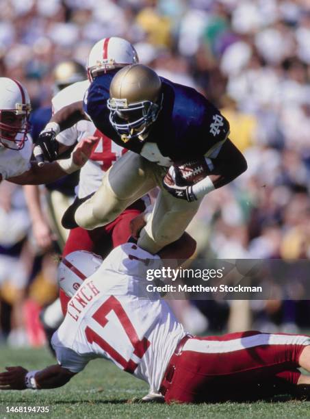 Lee Becton, Running Back for the Notre Dame Fighting Irish in motion running the football is tackled by John Lynch, Defensive Back for the Stanford...