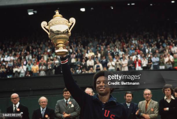 American tennis player Arthur Ashe holds up his trophy after winning the men's singles of the Wimbledon Tennis Championship in London on July 5th,...