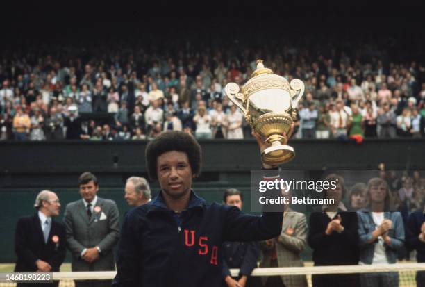 American tennis player Arthur Ashe holds up his trophy after winning the men's singles of the Wimbledon Tennis Championship in London on July 5th,...