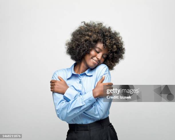 portrait of a young businesswoman hugging herself - ethnicity stock pictures, royalty-free photos & images