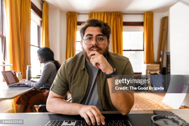 portrait of young businessman on video call in office - webcam stock-fotos und bilder