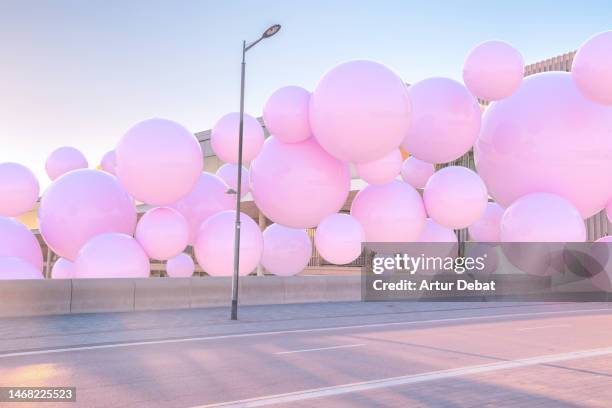 digital 3d picture of pink balloons levitating and interacting with the city. - business celebration stock-fotos und bilder