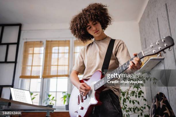 joven músico toca la guitarra eléctrica - guitarra eléctrica fotografías e imágenes de stock
