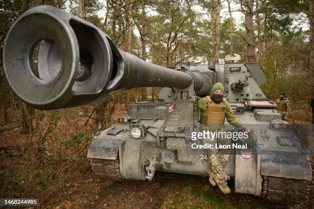 Ukrainian volunteer Andriy poses for a photograph on an AS90 155mm self-propelled artillery system during a break in a training session with members...