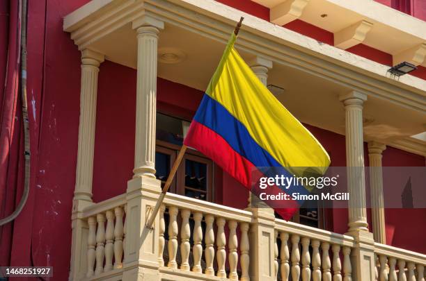 colombian national flag flying from a balcony flagpole on a colonial building - colombia pattern stock pictures, royalty-free photos & images