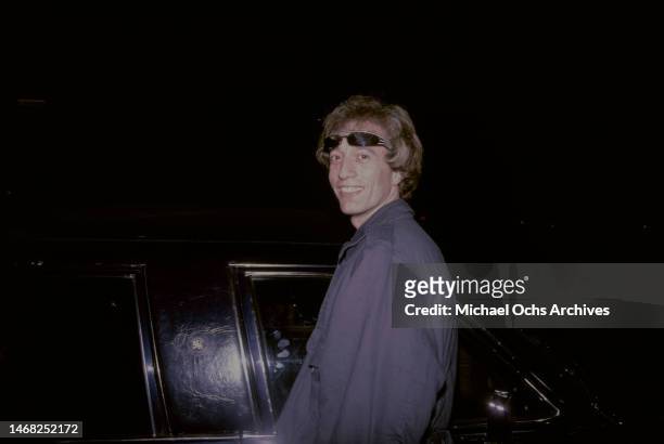 Robert Gibb smiles as he gets in a car, circa 1980s.