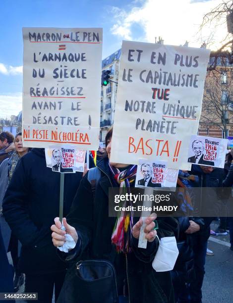 Manifestants avec des pancartes "Macron=Le Pen= L'arnaque du siècle réagissez avant le désastre ! ni peste ni choléra" et "Et en plus le capitalisme...