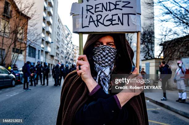 Une femme porte une pancarte "RENDEZ L"ARGENT" lors de la quatrième journée de manifestation contre la réforme reculant l'âge de départ à la retraite...