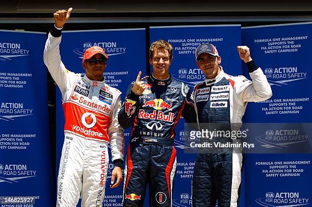 Pole sitter Sebastian Vettel of Germany and Red Bull Racing poses for a photo with Lewis Hamilton of Great Britain and McLaren and Pastor Maldonado...