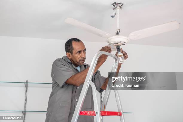 electrician repairs the ceiling fan - fan of his work stock pictures, royalty-free photos & images