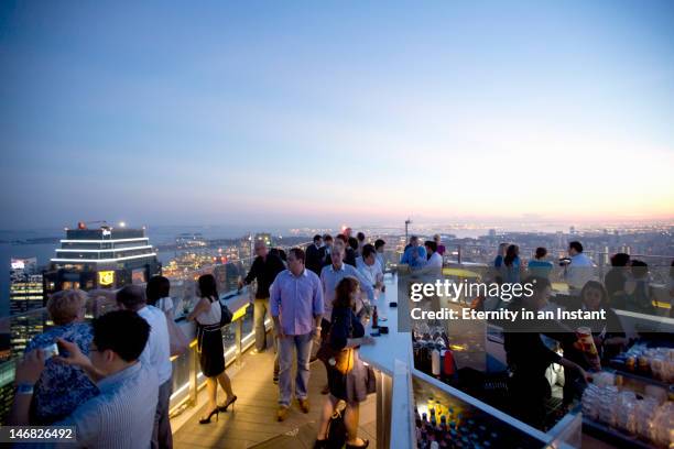 people enjoying sunset from rooftop bar - nightlife bar stock pictures, royalty-free photos & images