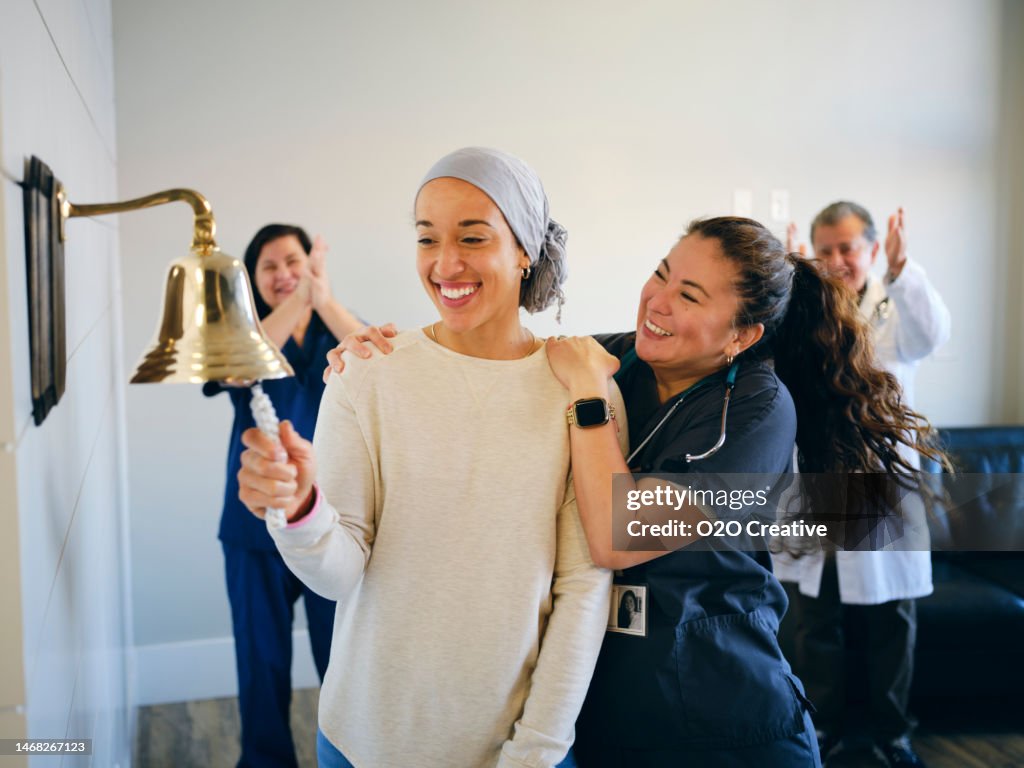Erwachsene Frau Chemotherapie Patientin beendet Behandlung mit einem zeremoniellen Glockenring