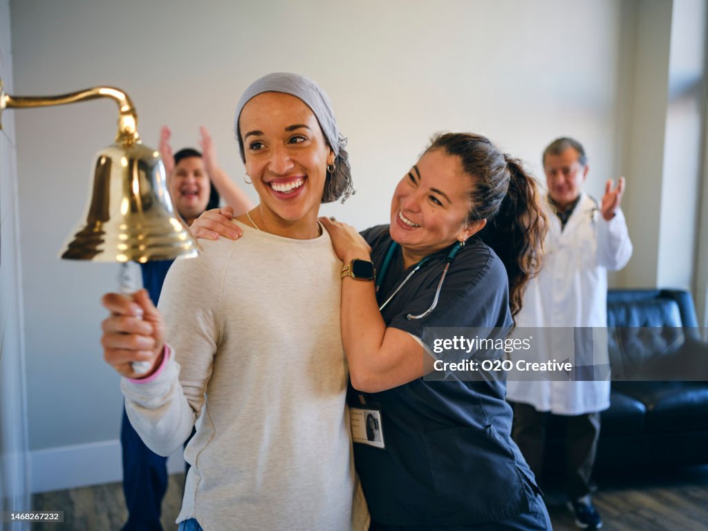Adult Woman Chemotherapy Patient Finishing Treatment with a Ceremonial Bell Ring
